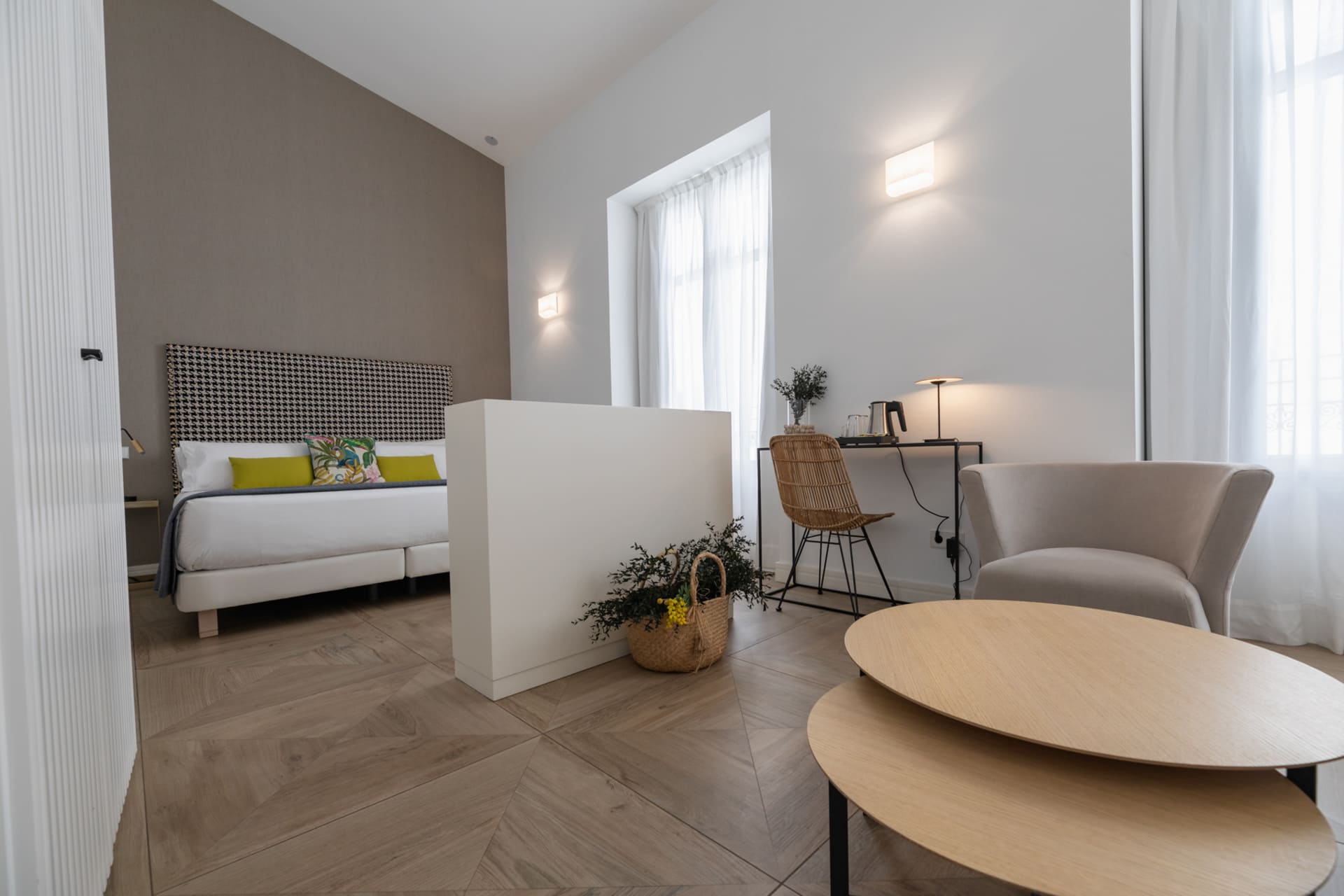 Habitación de hotel moderna con cama grande, área de trabajo y zona de estar.