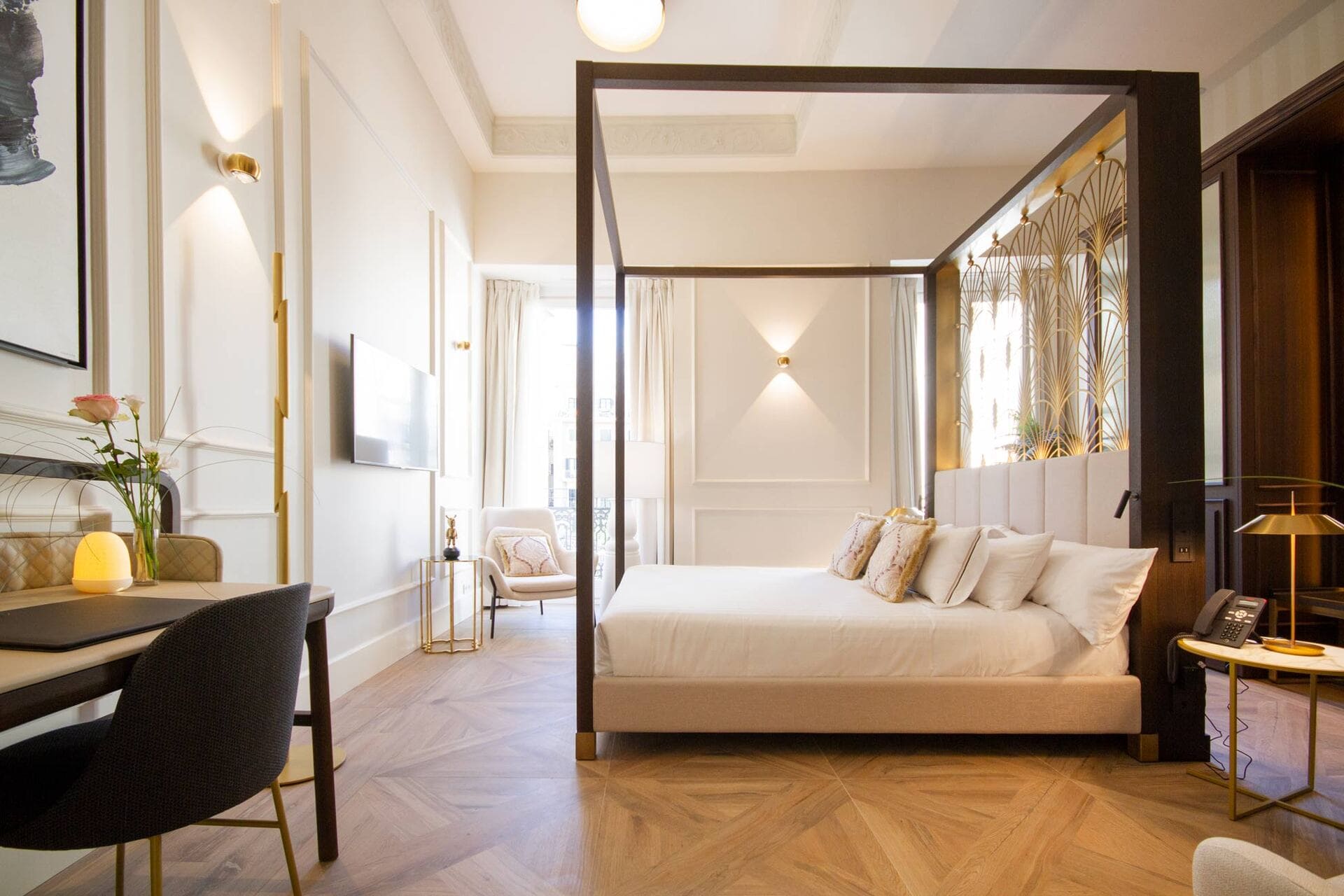 Habitación de hotel con cama de cuatro postes y zona de descanso