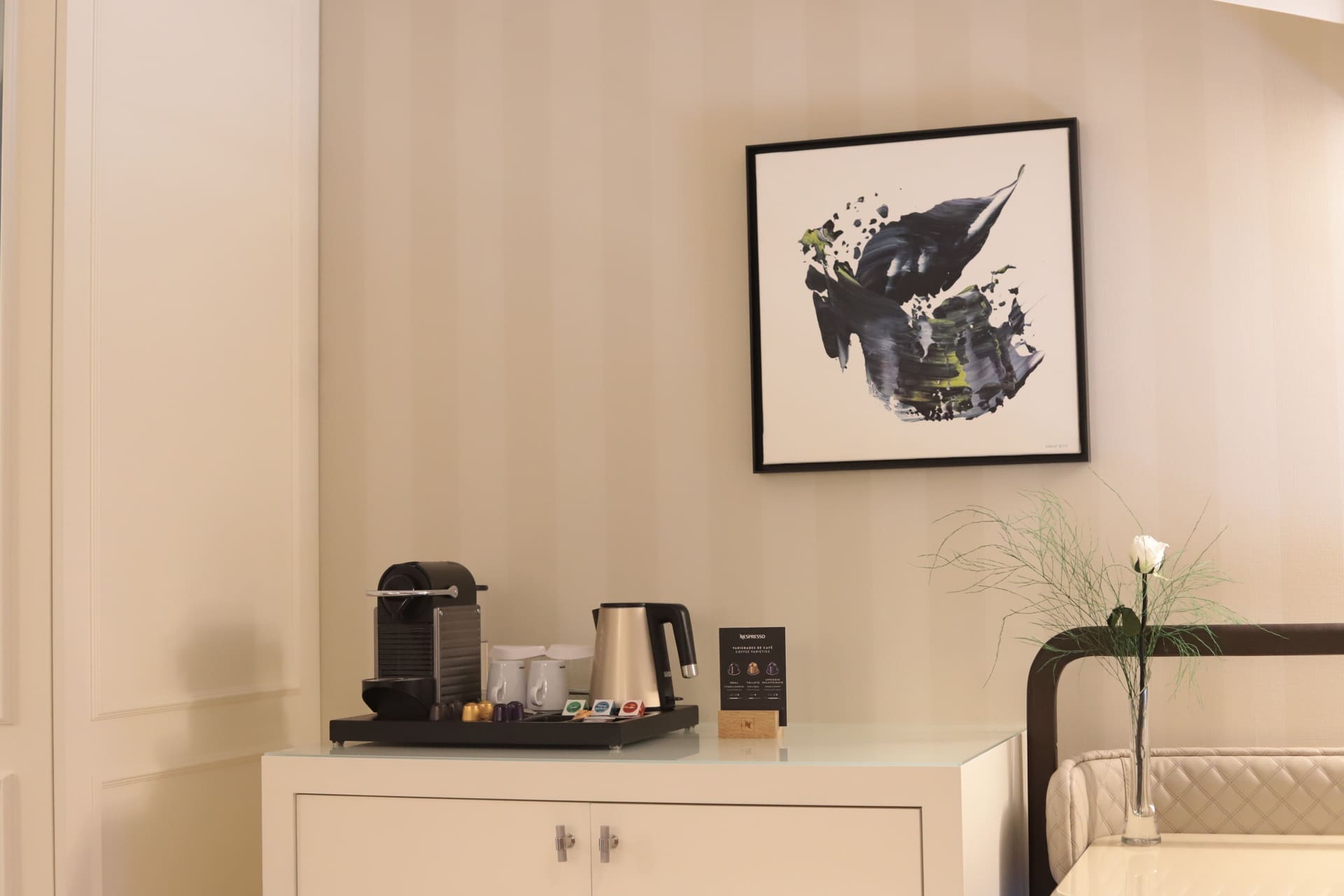 Zona de café Nespresso en habitación, junto a un cuadro abstracto