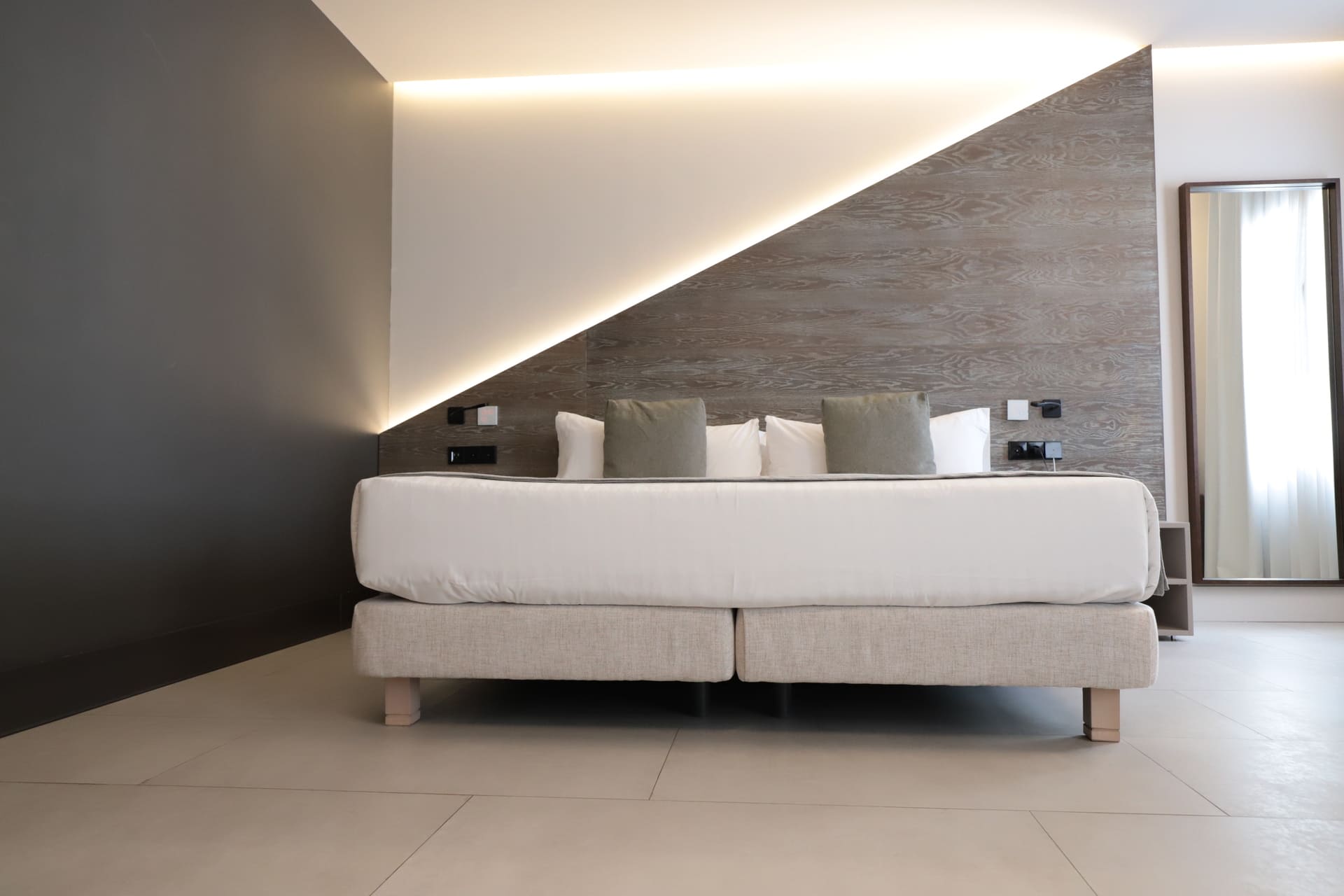 Habitación de hotel con cama grande y cabecera de madera en diagonal