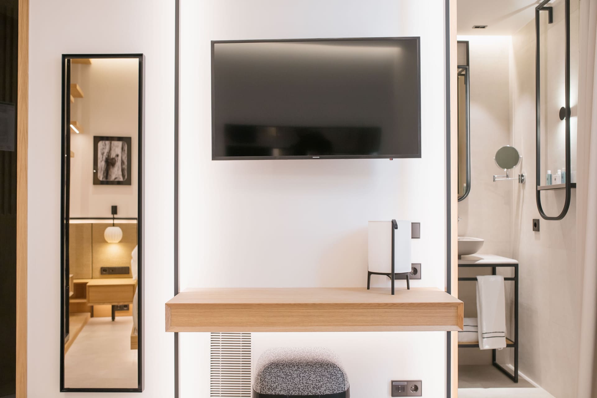 Habitación de hotel con televisor de pared y baño al fondo