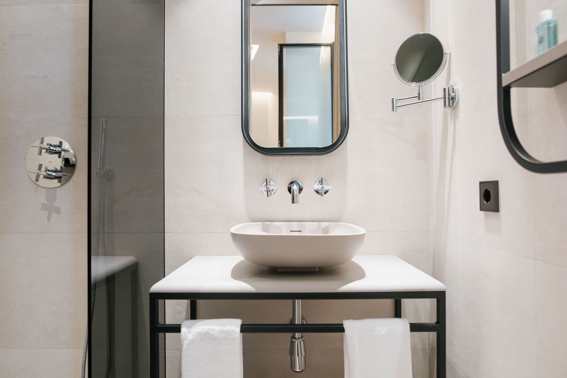 Lavabo ovalado sobre encimena blanca en baño moderno con espejo