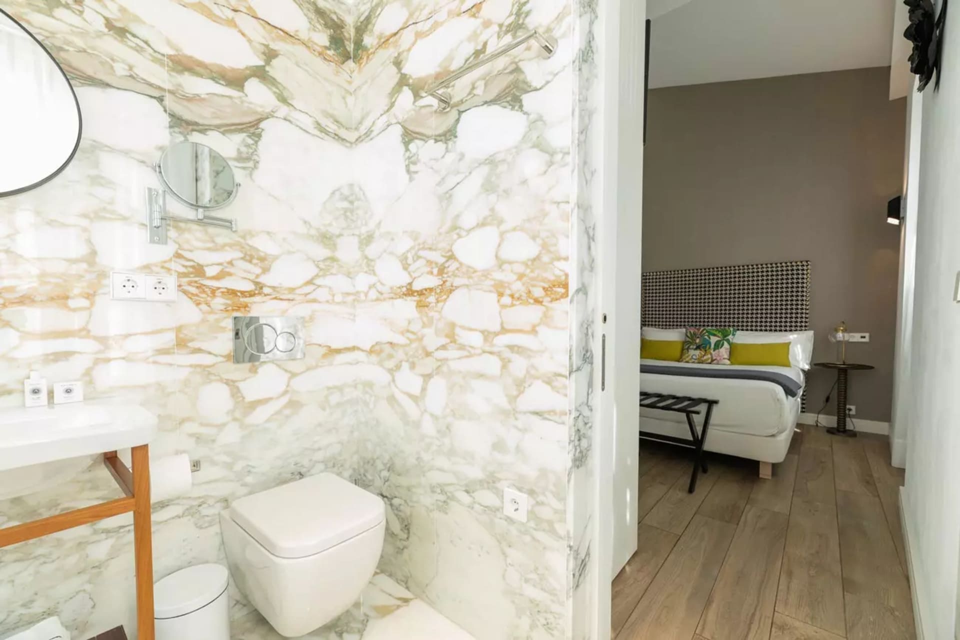 Baño de mármol en suite con lavabo y WC, que se abre a habitación con cama