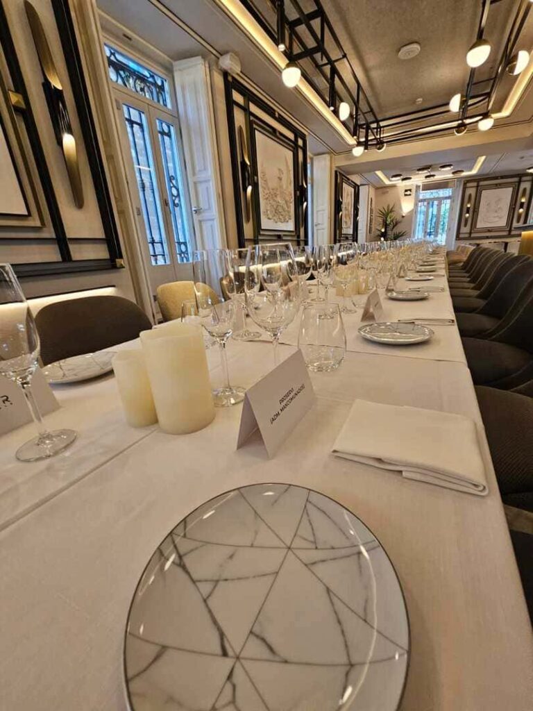 Mesa de banquete larga con vajilla y velas en salón elegante