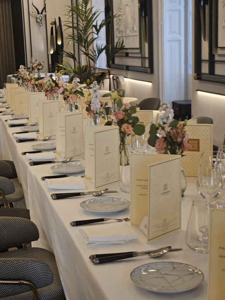 Mesa de banquete para evento con menús y arreglos florales