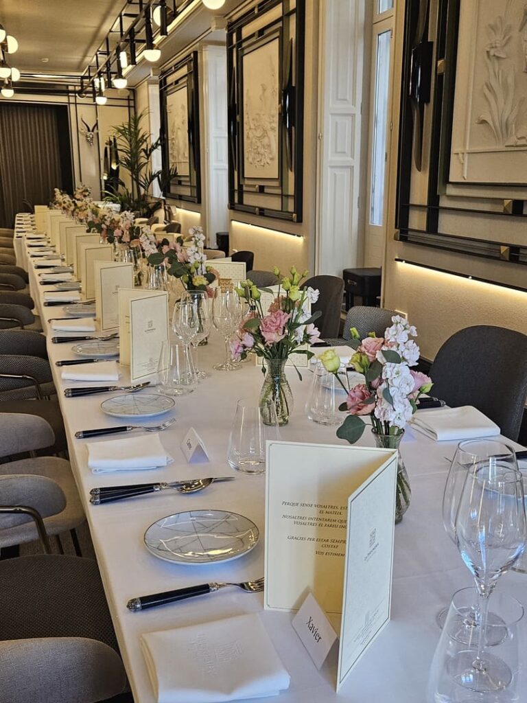 Banquete en salón de eventos con mesa larga, vajilla y arreglos florales