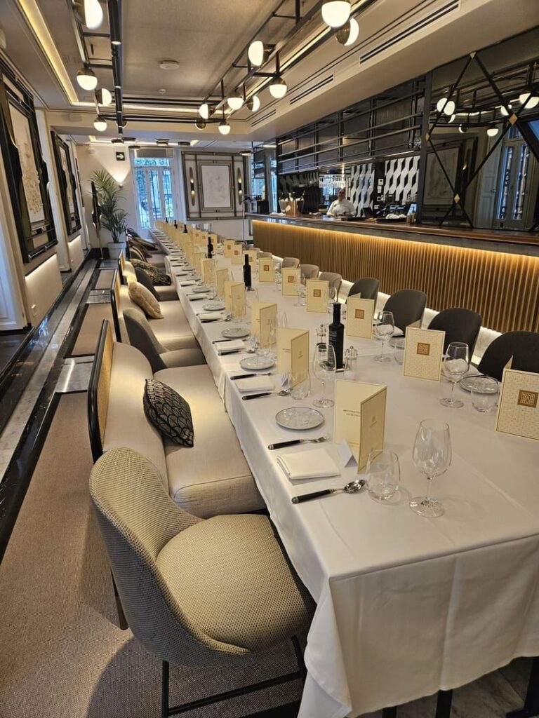 Banquete con mesa larga en sala de eventos, menús y copas