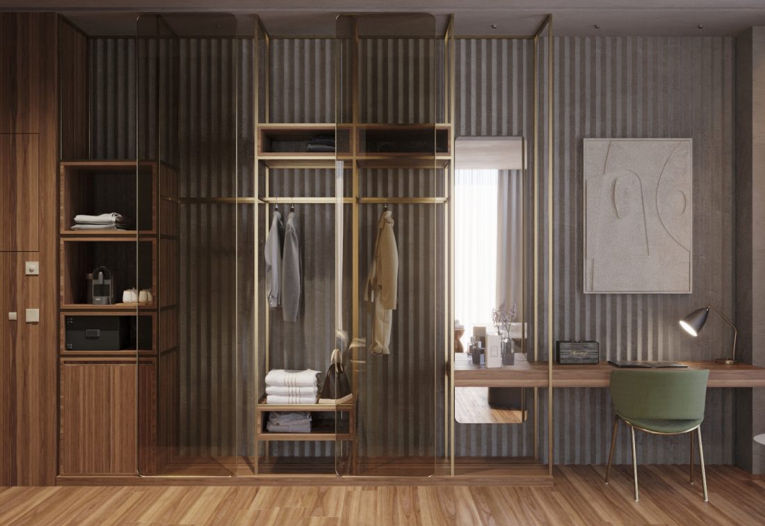 Vestidor abierto con ropa y toallas junto a escritorio en habitación de hotel