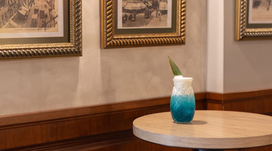 Cóctel azul en vaso de vidrio tallado con hoja en Café Madrid Valencia
