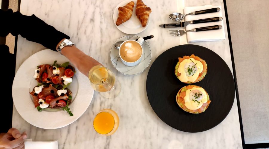 Desayuno: huevos benedictinos, ensalada de burrata y tomates, croissants y café.