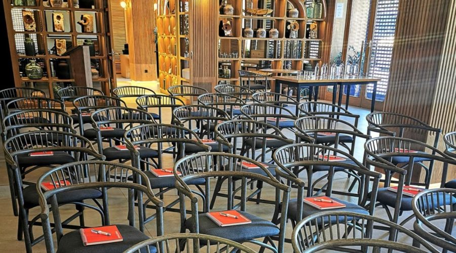 Salón de conferencias de MYR Hotels con filas de sillas negras y cuadernos rojos.