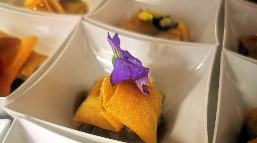 Canapé dorado con flor comestible morada en evento corporativo de MYR Hotels