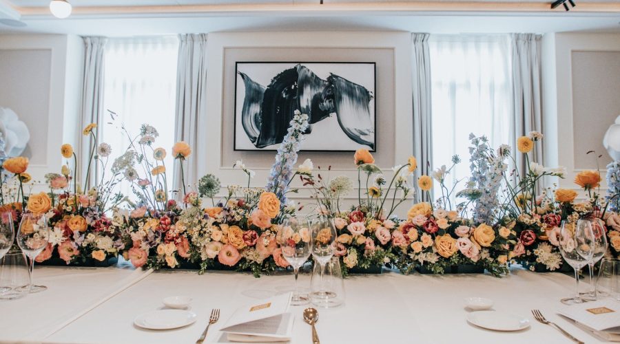 Mesa de banquete con amplio arreglo floral en sala de eventos