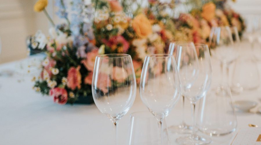 Mesa de banquete con copas de vino y centro floral colorido