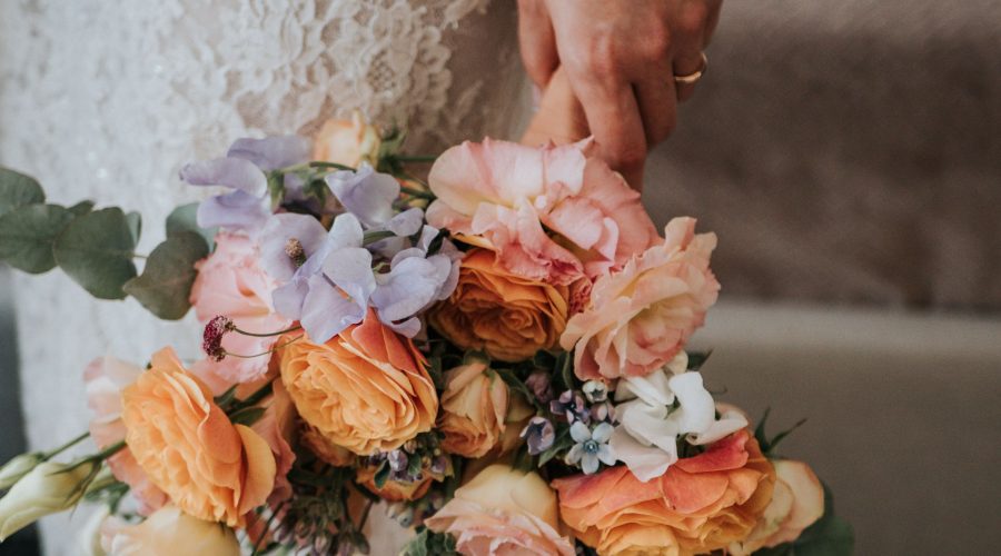 Ramo de novia con rosas naranjas y flores lilas