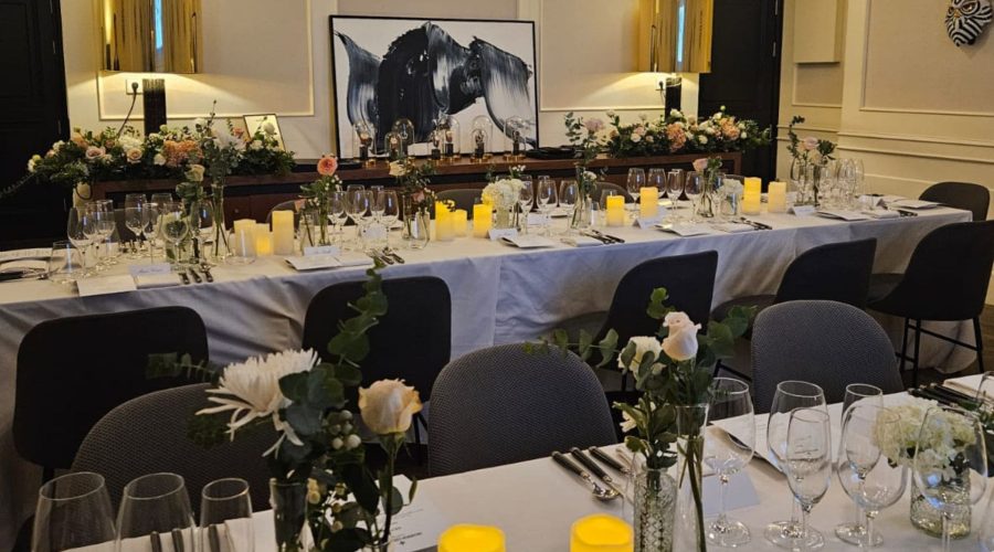 Banquete en salón de eventos con mesa larga, velas y arreglos florales
