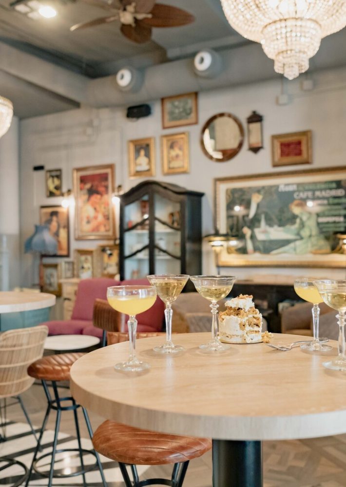 Mesa redonda con copas y pastel en café decorado vintage