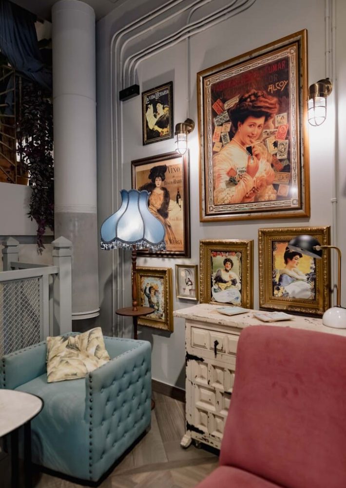 Interior de Café Madrid Valencia con sillón azul, lámparas y cuadros vintage