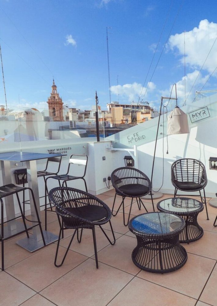 Azotea de Café Madrid con sillas de ratán y vistas al centro de Madrid