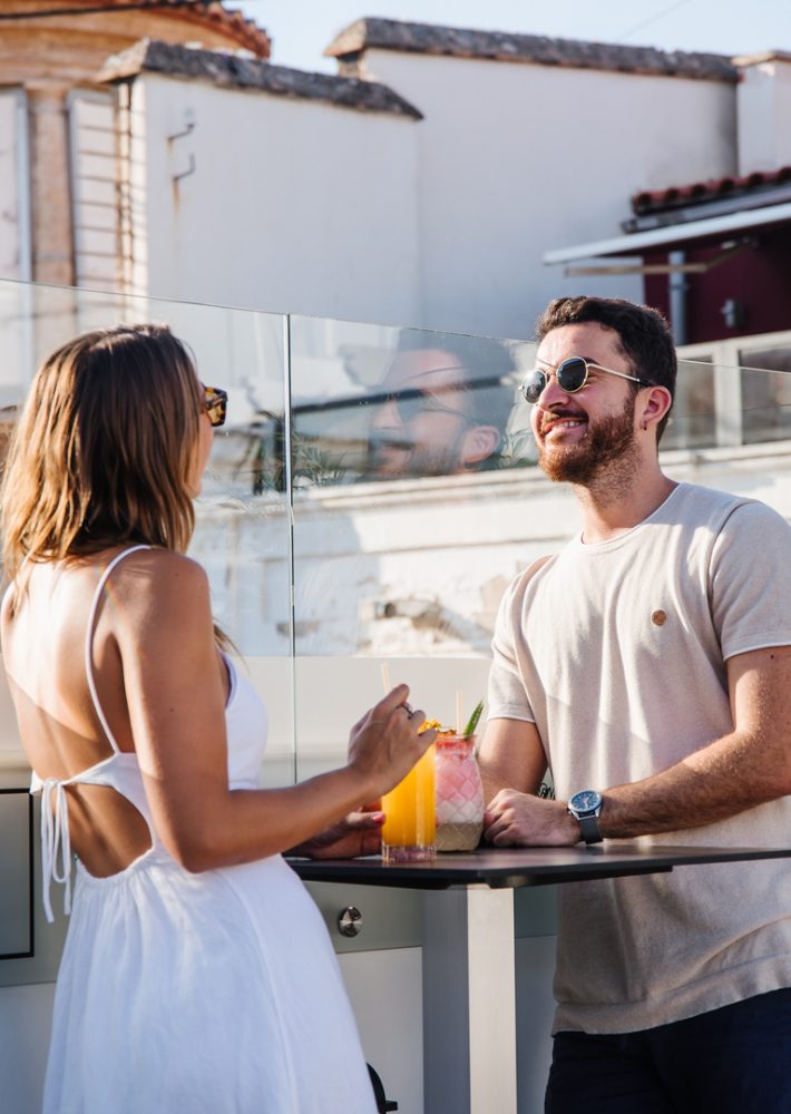 Pareja bebiendo cócteles en terraza de café en Madrid