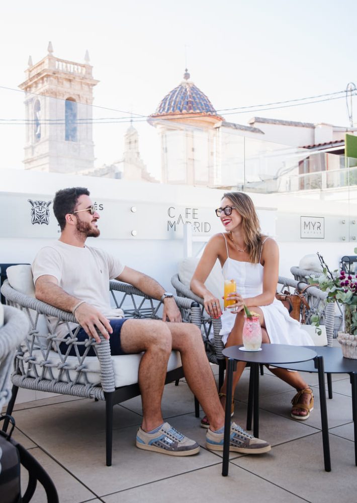 Pareja en azotea de café en Madrid, disfrutando de bebidas
