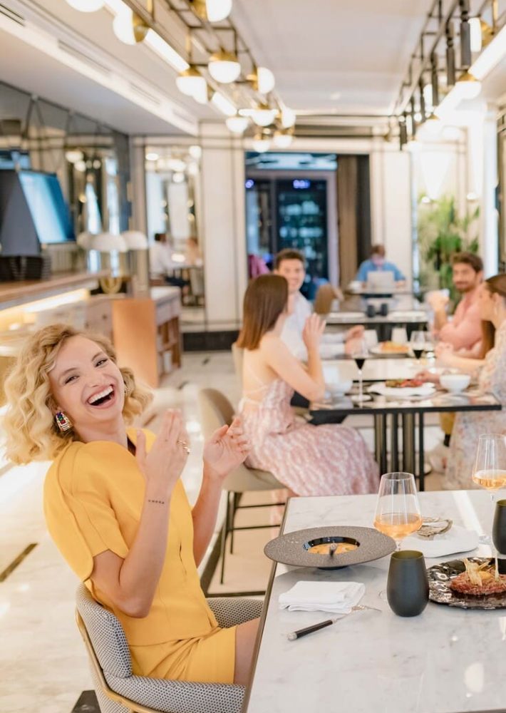 Mujer con vestido amarillo riendo en La Perfumería