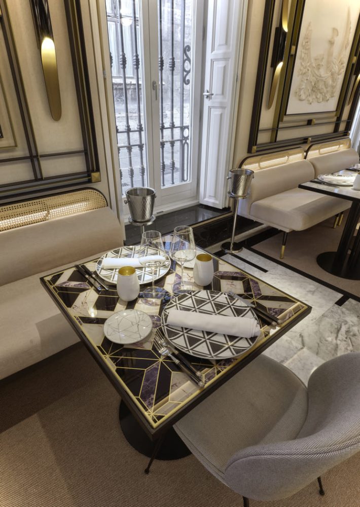 Mesa de comedor elegante en La Perfumería con vajilla geométrica y copas.