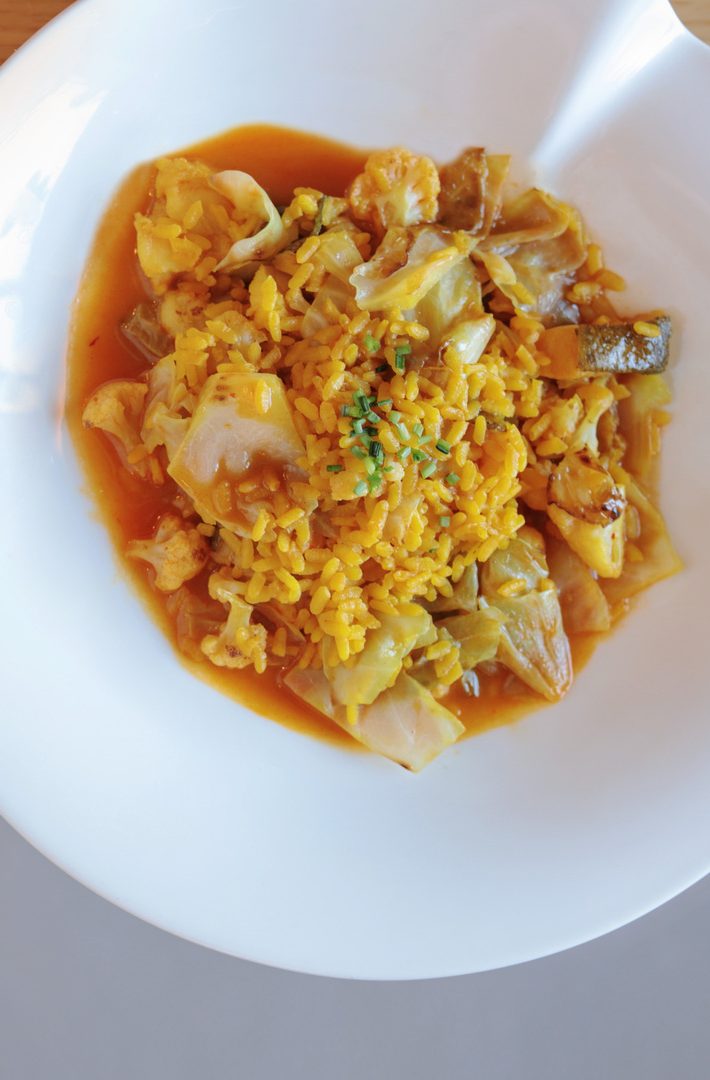 Arroz amarillo con verduras en plato blanco