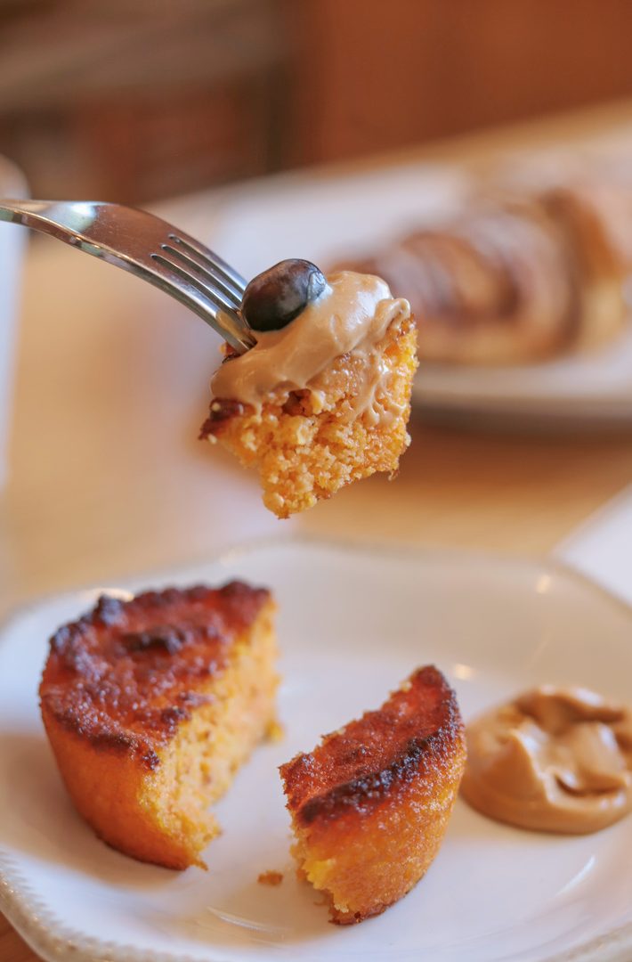 Bocado de pastel con glaseado cremoso y arándano sobre tenedor