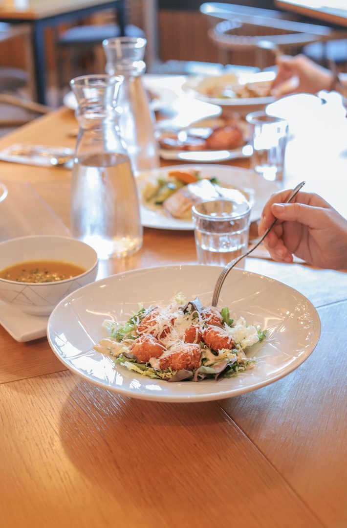 Ensalada con crutones y queso parmesano en mesa de restaurante