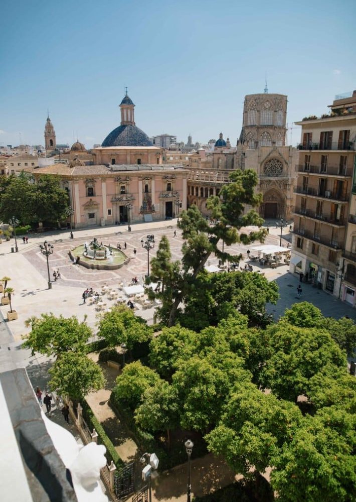 Vista desde la azotea del lounge hacia la plaza histórica con fuente y catedral