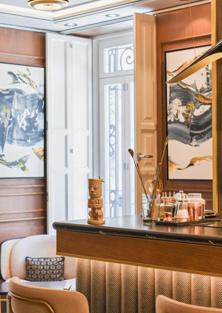 Bar lounge elegante con barra de madera y figura tiki decorativa