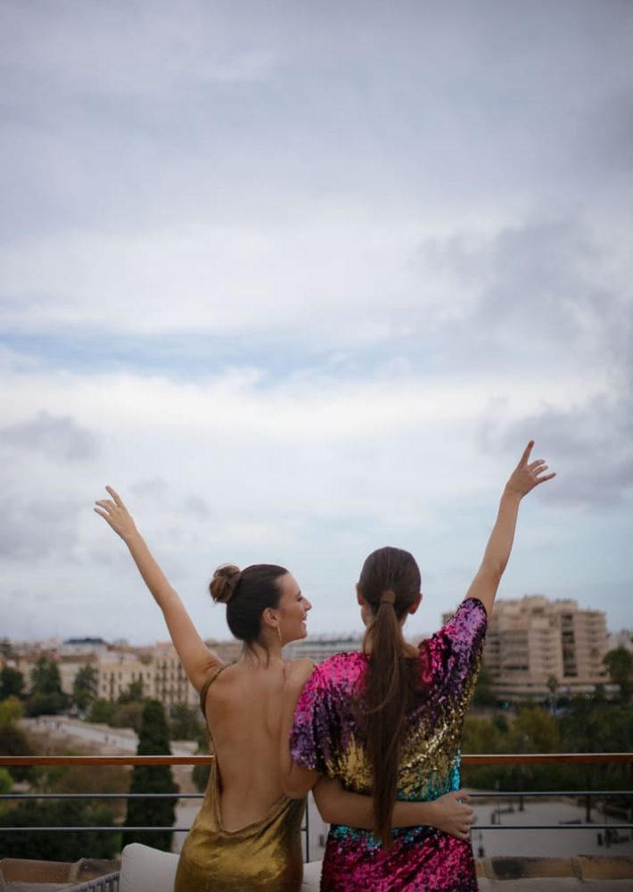 Dos mujeres en la azotea de Luna Valencia con vestidos brillantes