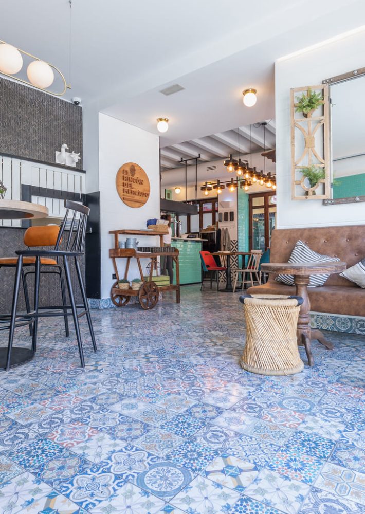 Interior del restaurante Rincón del Mercado con suelo de azulejos coloridos y zona de estar.