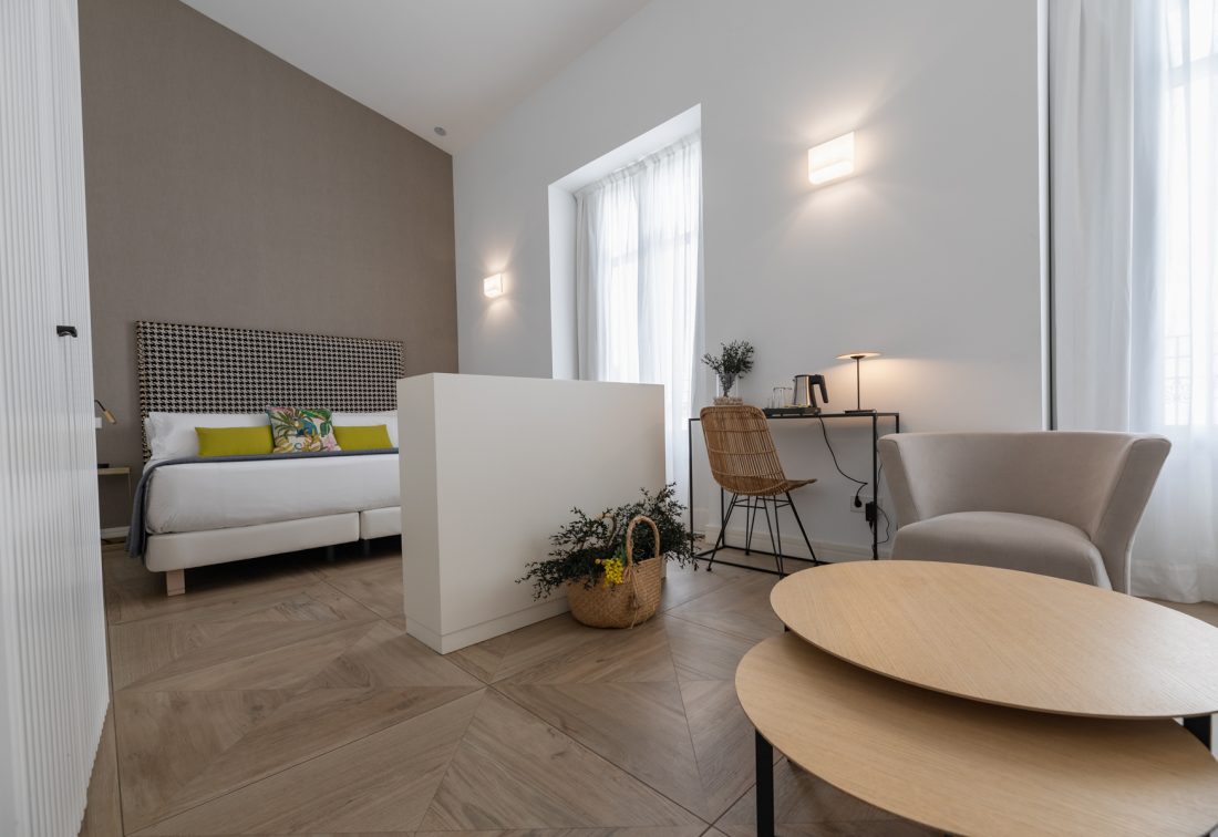Suite junior en Hotel Marqués House: cama con cabecera acolchada, área de trabajo y rincón de descanso.