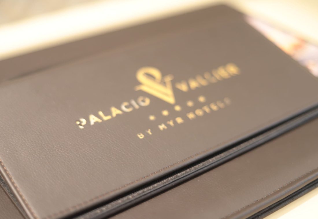 Carpeta de cuero marrón con logotipo dorado de Palacio Vallier