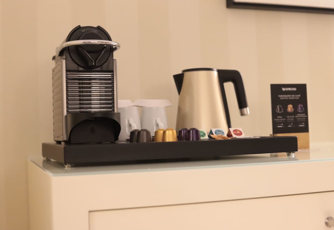 Estación de café con cafetera Nespresso y hervidor en habitación de hotel