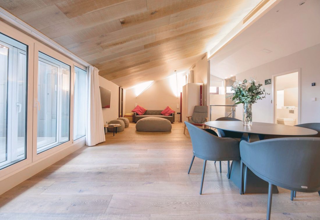 Suite amplia con sala de estar y mesa de comedor, ventanales grandes