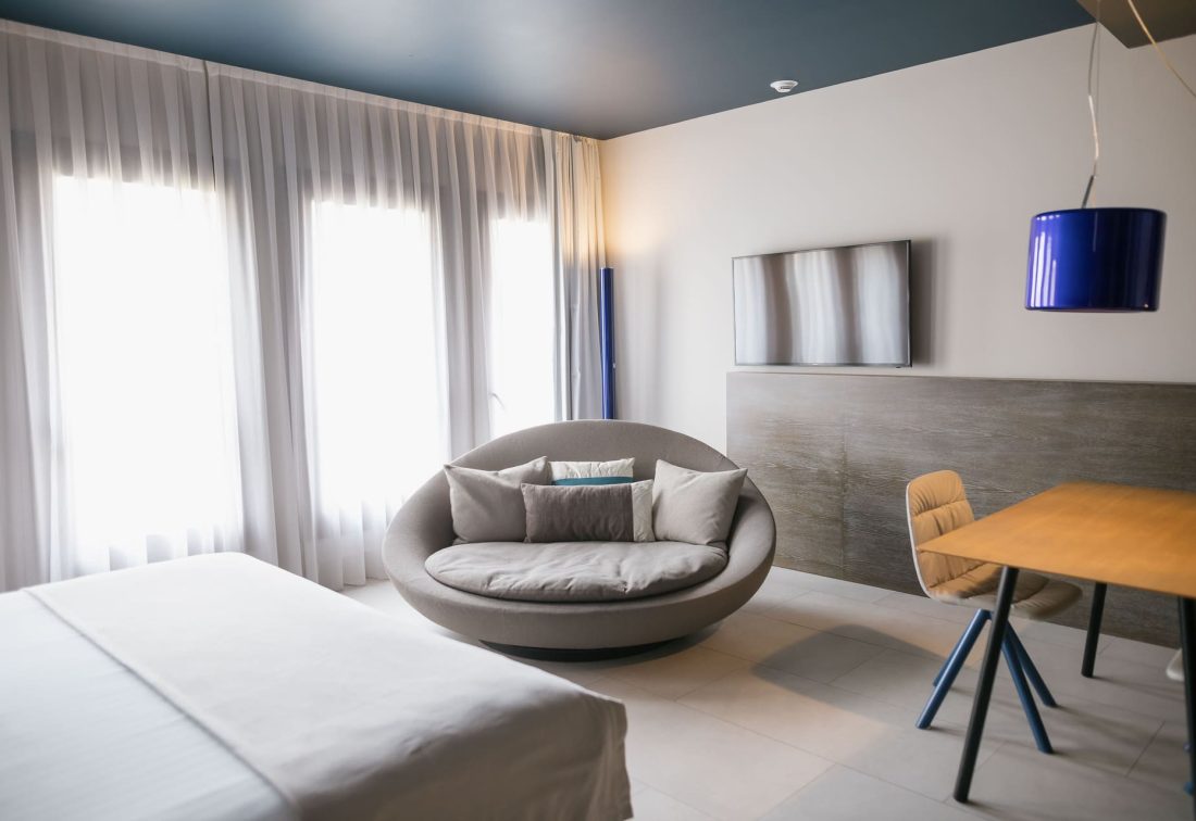 Sofá circular con cojines en la sala de estar de la habitación de hotel