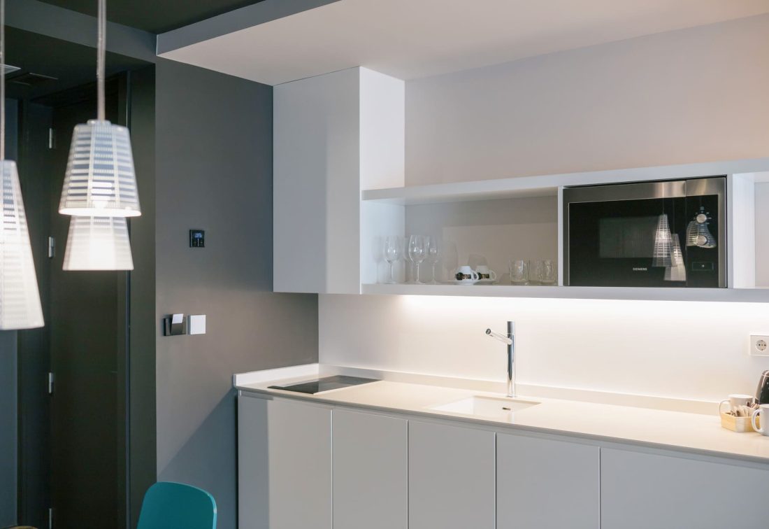 Cocina de suite moderna con fregadero, placa de inducción y microondas empotrado