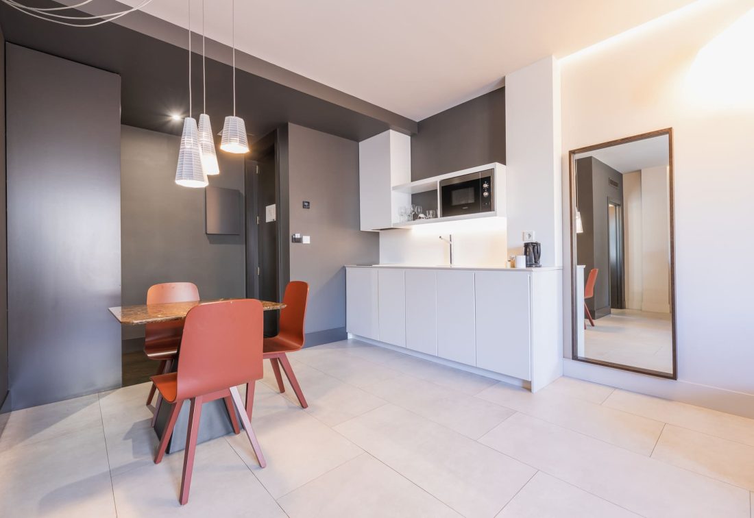 Cocina moderna en apartamento hotelero con mesa y sillas coral