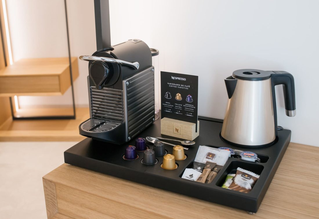 Máquina de café Nespresso y hervidor en bandeja de amenities de habitación