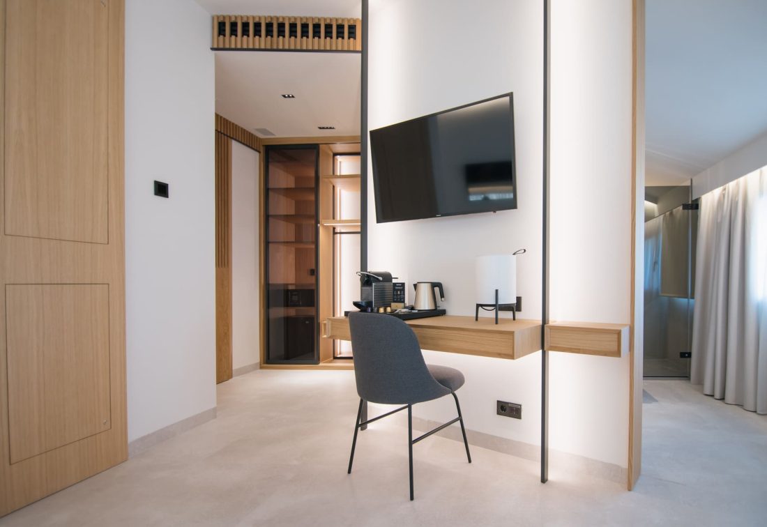 Zona de trabajo en habitación de hotel con escritorio flotante, TV y cafetera