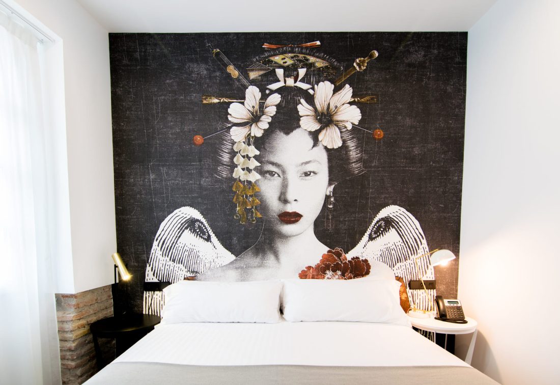 Habitación con mural de geisha y flores detrás de la cama