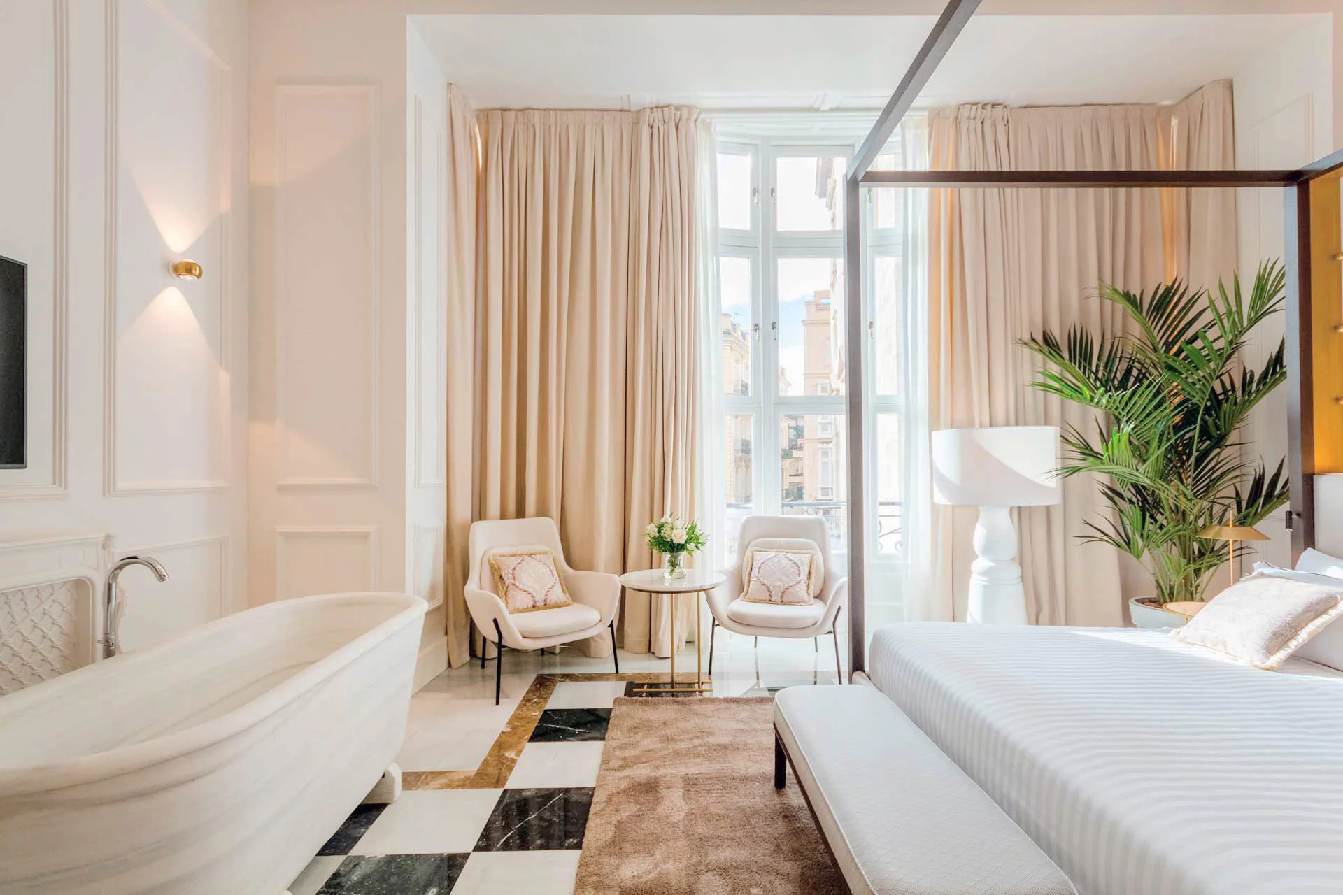 Suite elegante con vasca indipendente, due poltrone e grande finestra