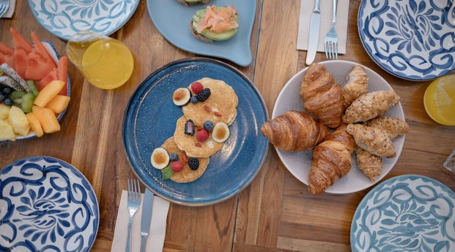 Desayuno en Rincón del Mercado: croissants y pancakes con frutas en mesa